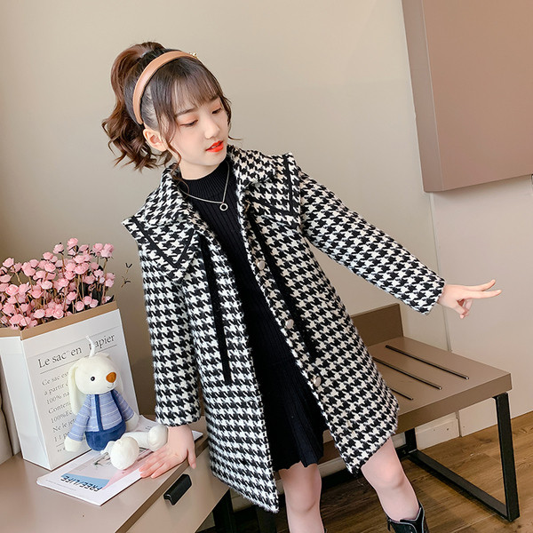 Must-valge ja taskutega lastemantel