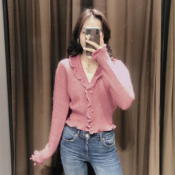 Lühike kootud vest lokkide ja spitsikaelusega