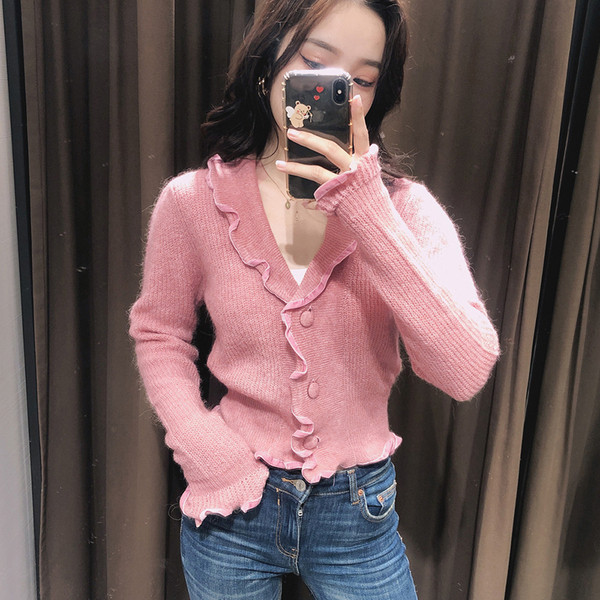 Lühike kootud vest lokkide ja spitsikaelusega