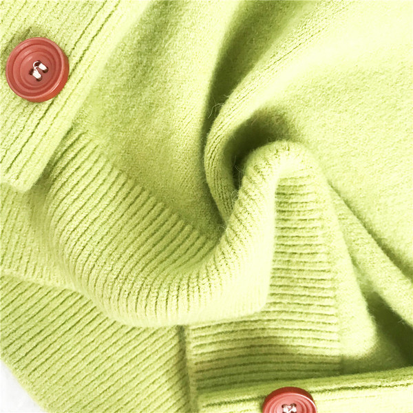 Modernus moteriškas megztinis su apvalia iškirpte ir spalvotomis sagomis