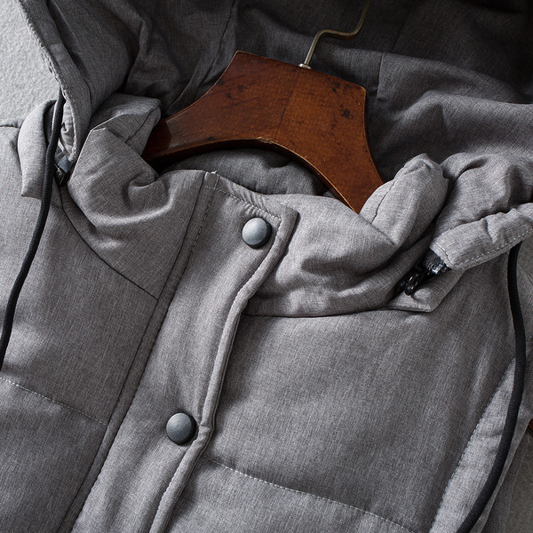 Tepitud soe vest nööpide ja kapuutsiga