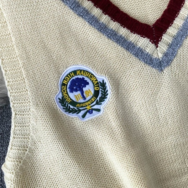 Γυναικείο πλεκτό γιλέκο με ντεκολτέ και έμβλημα