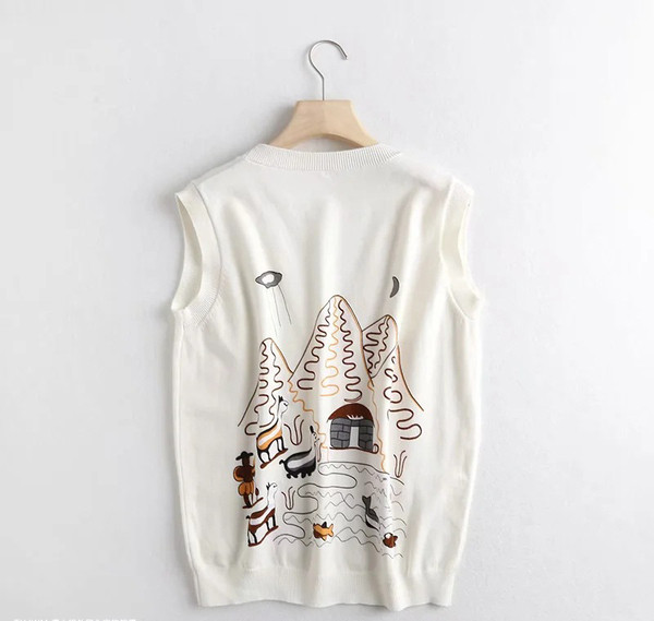 Moteriška megzta liemenė su aplikacijomis ir sagomis