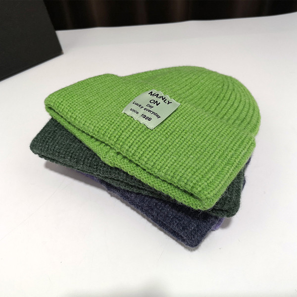 Női kötött sapka különböző színű emblémával