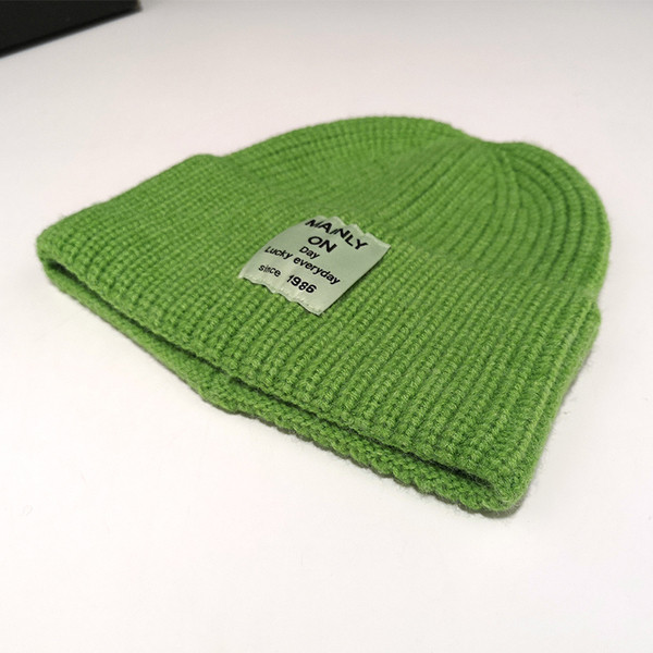 Női kötött sapka különböző színű emblémával