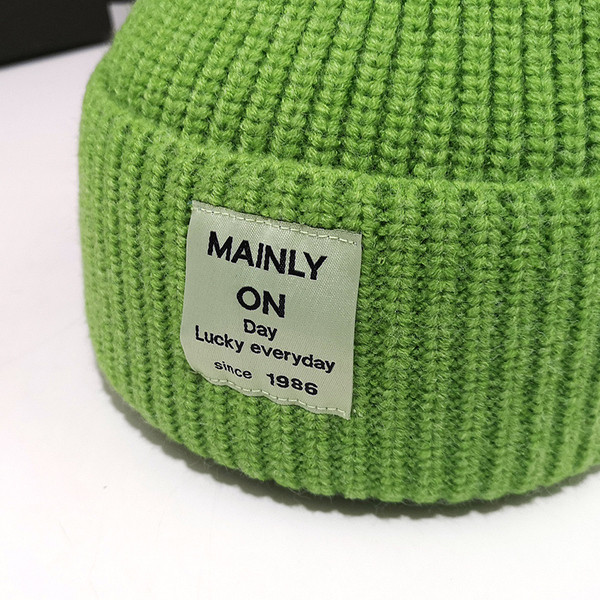 Női kötött sapka különböző színű emblémával