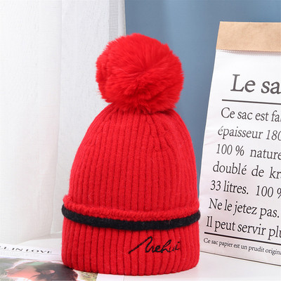 Moderna ženska pletena kapa s pomponom i vezom