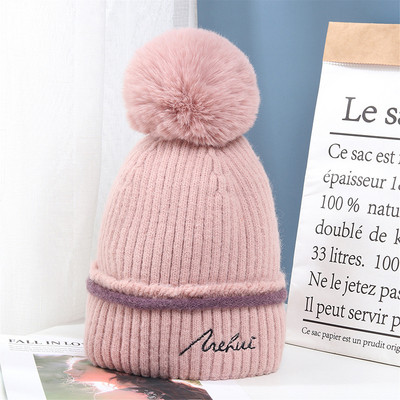 Moderna ženska pletena kapa s pomponom i vezom