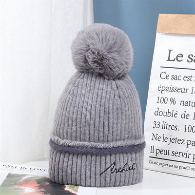 Moderna ženska pletena kapa s pomponom i vezom