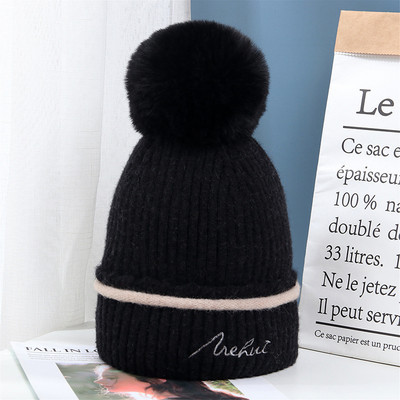 Moderna ženska pletena kapa s pomponom i vezom