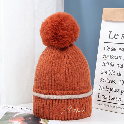 Moderna ženska pletena kapa s pomponom i vezom