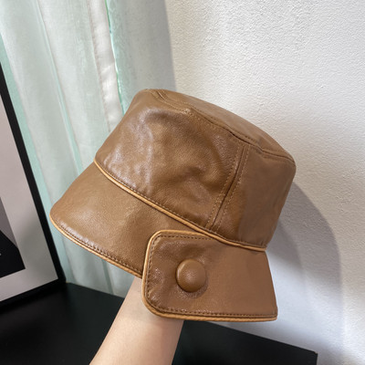 Aktuális női sapka műbőrből, gombbal