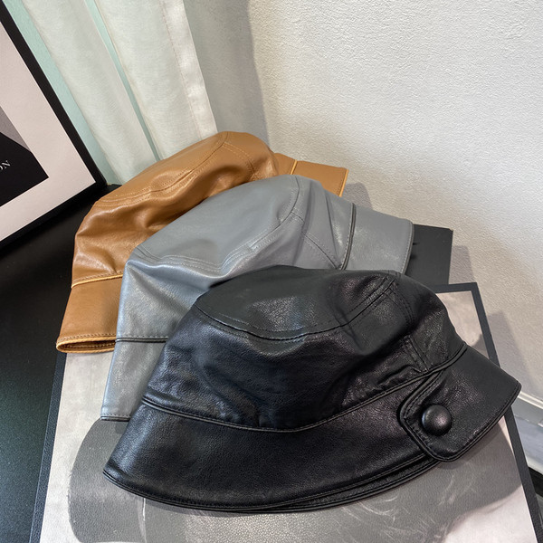 Aktuális női sapka műbőrből, gombbal