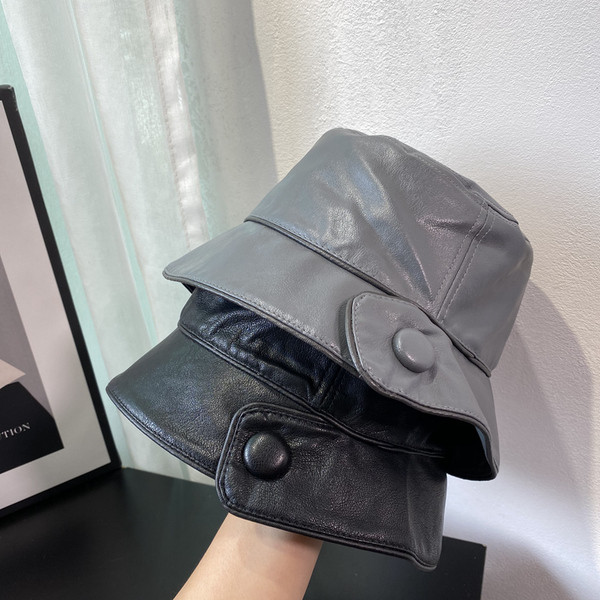 Aktuális női sapka műbőrből, gombbal