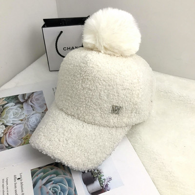 Hanem egy női kalapmodell fém elemmel, pomponnal