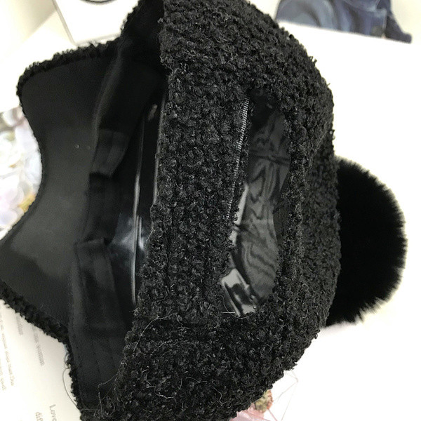 Hanem egy női kalapmodell fém elemmel, pomponnal