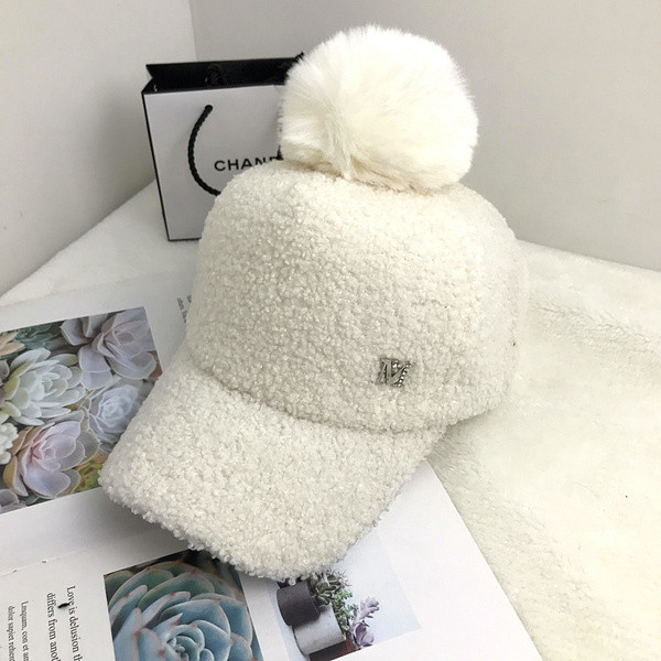 Hanem egy női kalapmodell fém elemmel, pomponnal