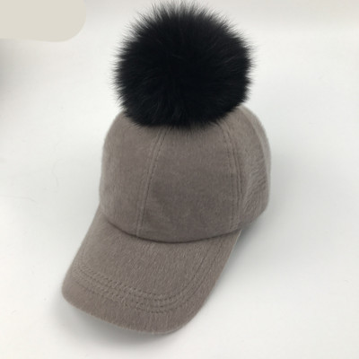 Modern női téli sapka tollal és napellenzővel