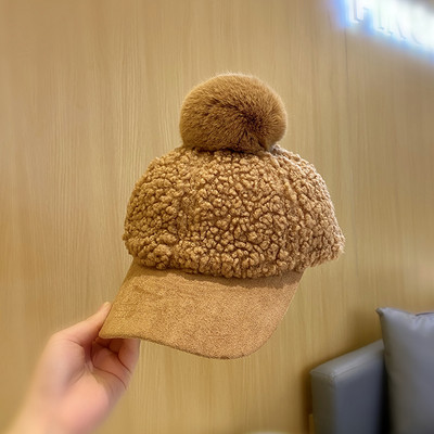 Stílusos női sapka tollal és napellenzővel