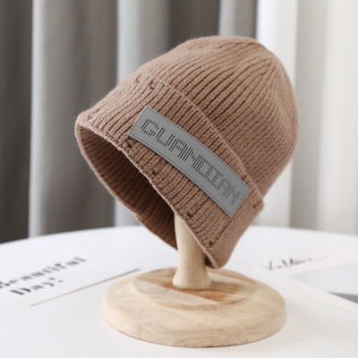 Hétköznapi kötött sapka emblémával, nőknek és férfiaknak egyaránt
