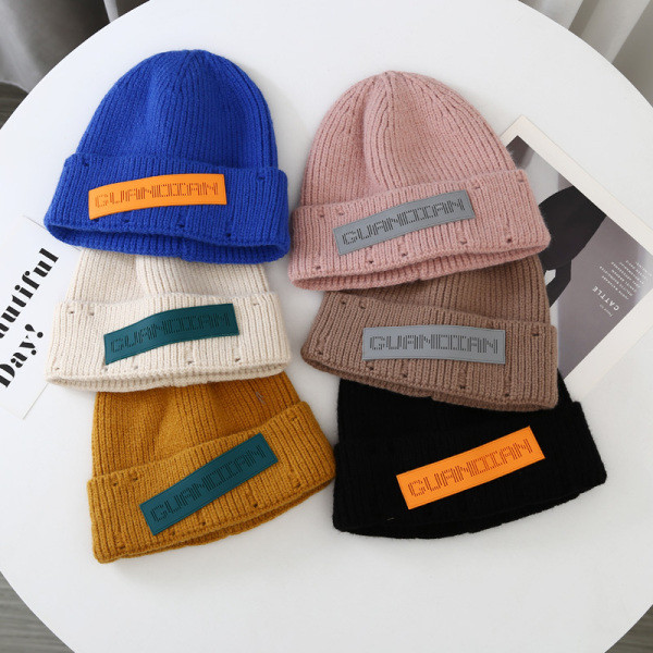 Hétköznapi kötött sapka emblémával, nőknek és férfiaknak egyaránt