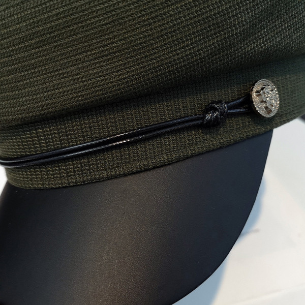 Korszerű női sapka fém elemmel és napellenzővel