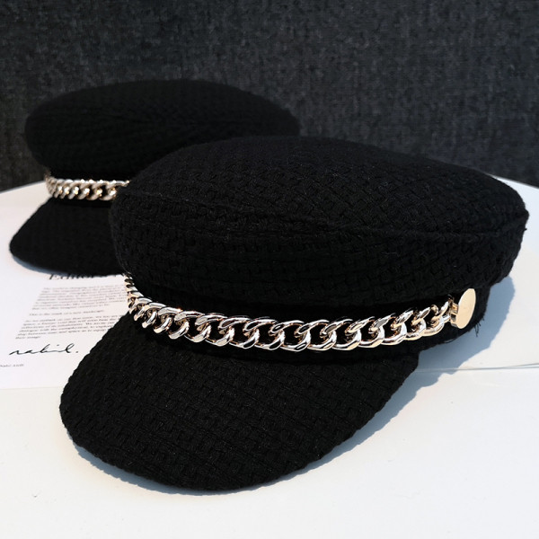 Fekete barett típusú női sapka fém elemmel