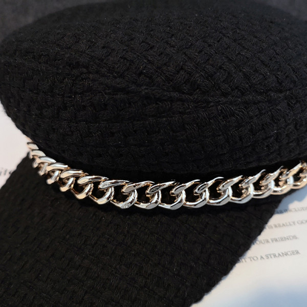 Fekete barett típusú női sapka fém elemmel