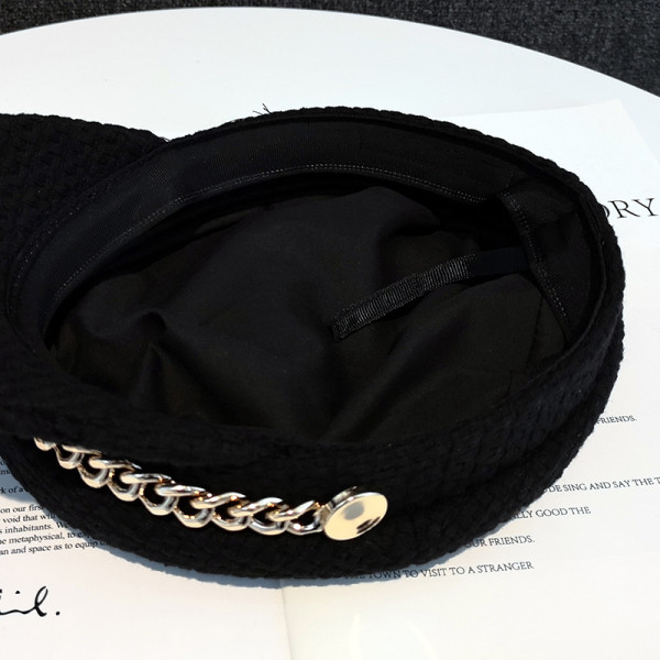 Fekete barett típusú női sapka fém elemmel