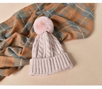 Pletena ženska kapa s paperjem pogodna za zimu