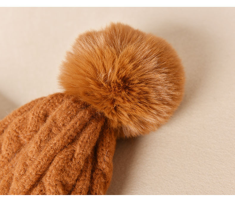 Pletena ženska kapa s paperjem pogodna za zimu