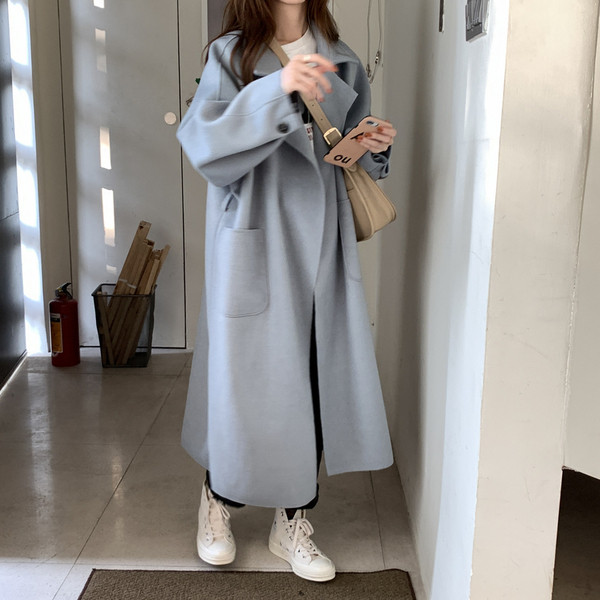 Hosszú női kabát zsebekkel és övvel