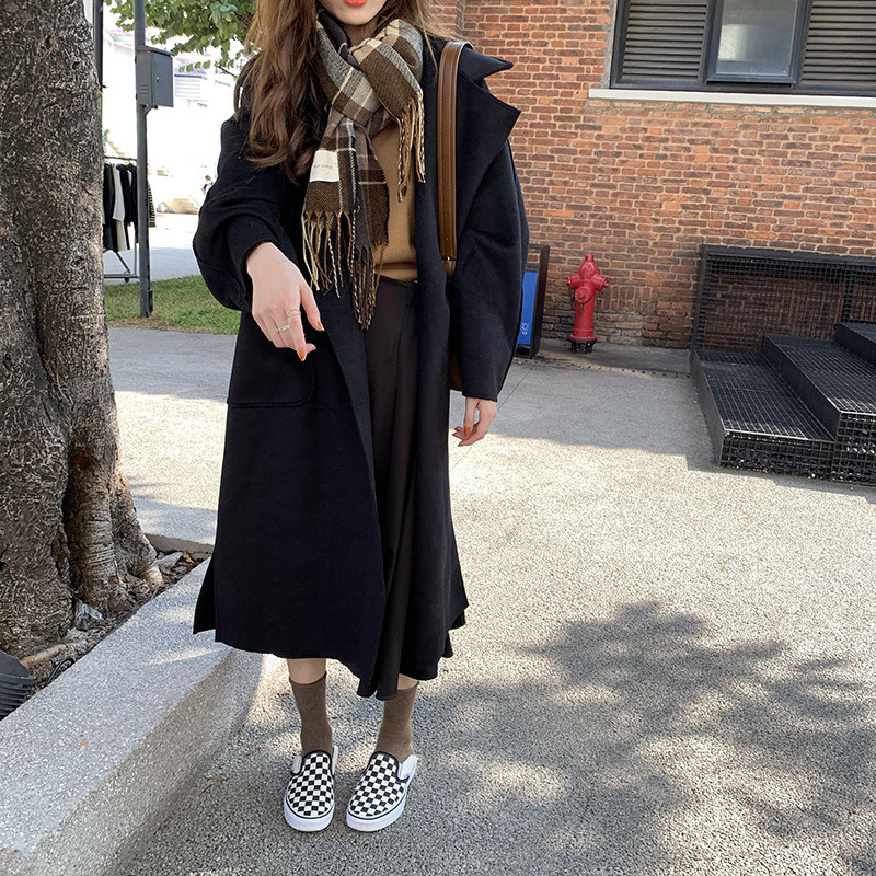 Hosszú női kabát zsebekkel és övvel