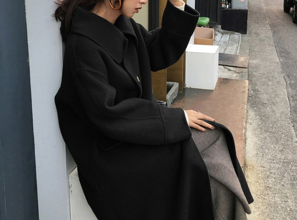 Hosszú télikabát fekete gombokkal és zsebekkel