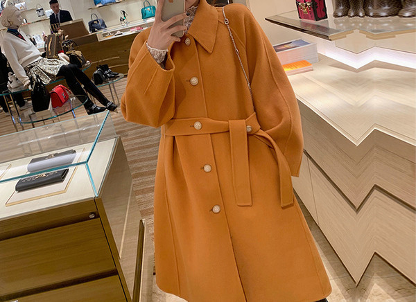 Modern női kabát magas gallérral és övvel narancssárga színben