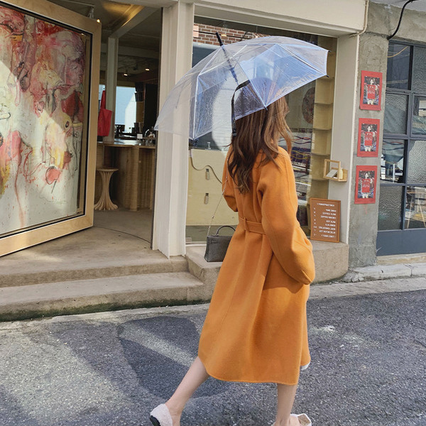 Modern női kabát magas gallérral és övvel narancssárga színben