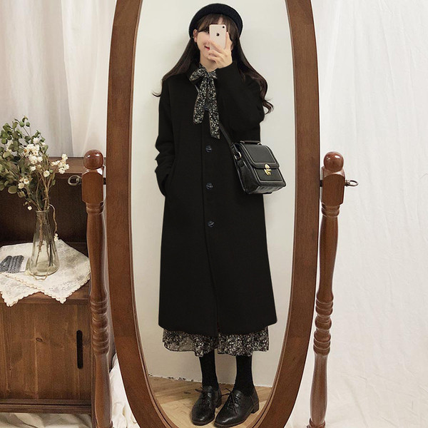 Fekete női kabát gombokkal és zsebekkel