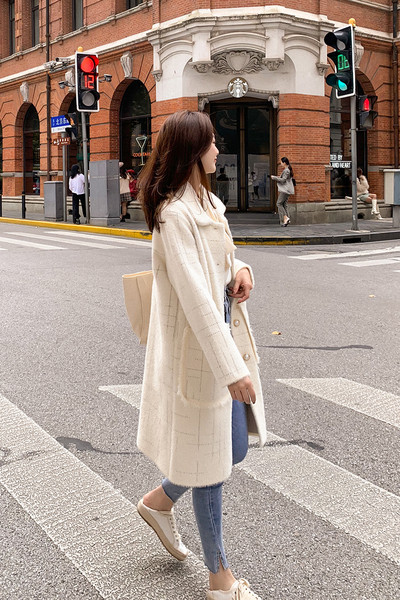 Pühös női hosszú kabát gombokkal és zsebekkel