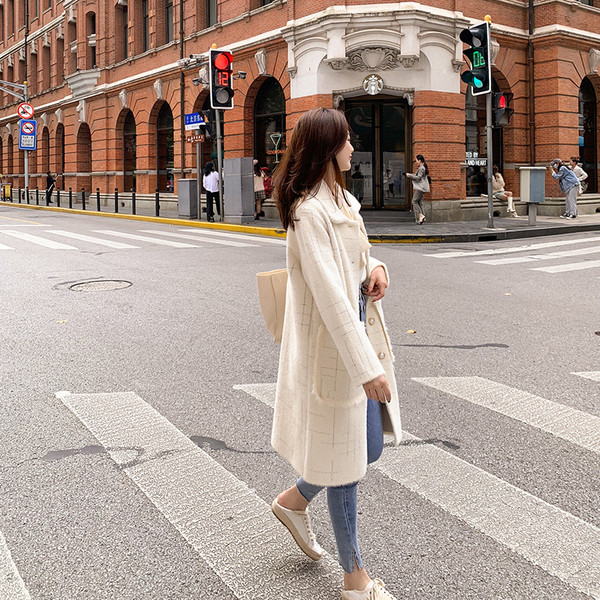 Pühös női hosszú kabát gombokkal és zsebekkel