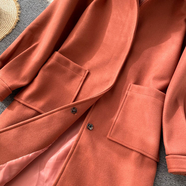 Hosszú női kabát klasszikus gallérral és zsebekkel