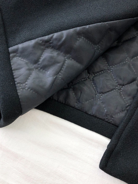 Fekete női kabát széles modell gallérral és zsebekkel