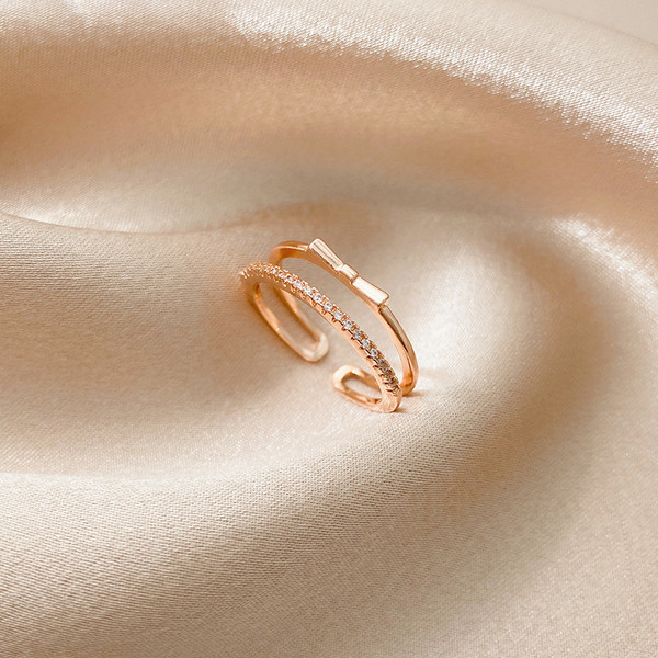 Modern női gyűrű szalaggal és díszkövekkel