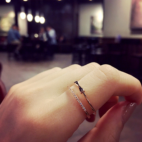 Modern női gyűrű szalaggal és díszkövekkel