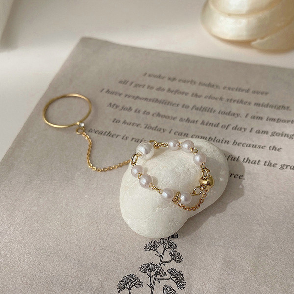 Hétköznapi női gyűrű lánccal és díszgyöngyökkel