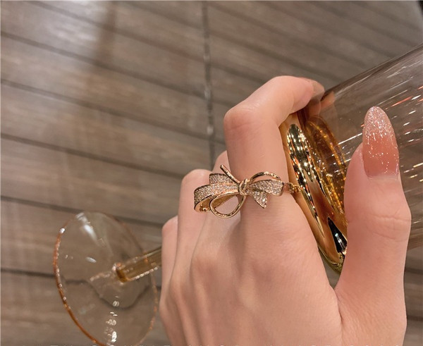 Stilīgs sieviešu gredzens ar dekoratīviem akmeņiem un lenti