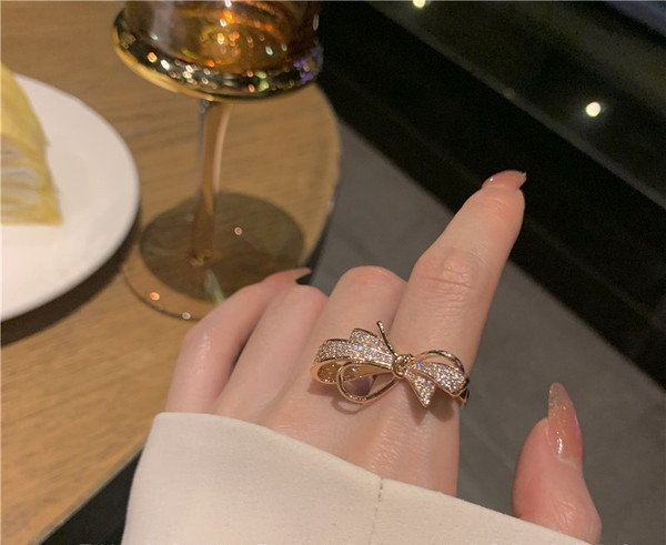 Stilīgs sieviešu gredzens ar dekoratīviem akmeņiem un lenti