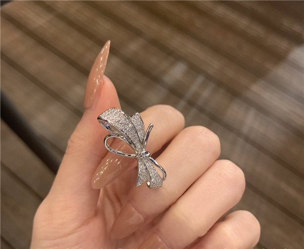 Stilīgs sieviešu gredzens ar dekoratīviem akmeņiem un lenti