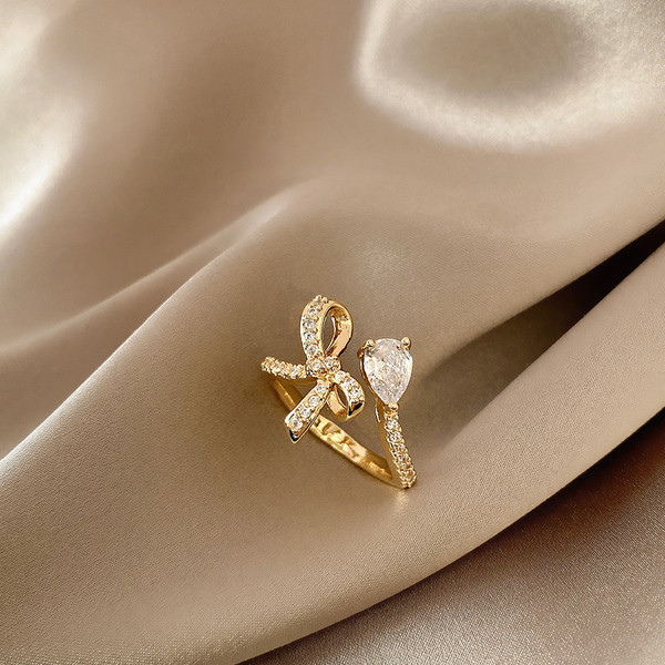 Stílusos női gyűrű szalaggal és díszkövekkel