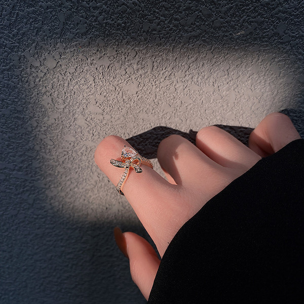 Stílusos női gyűrű szalaggal és díszkövekkel