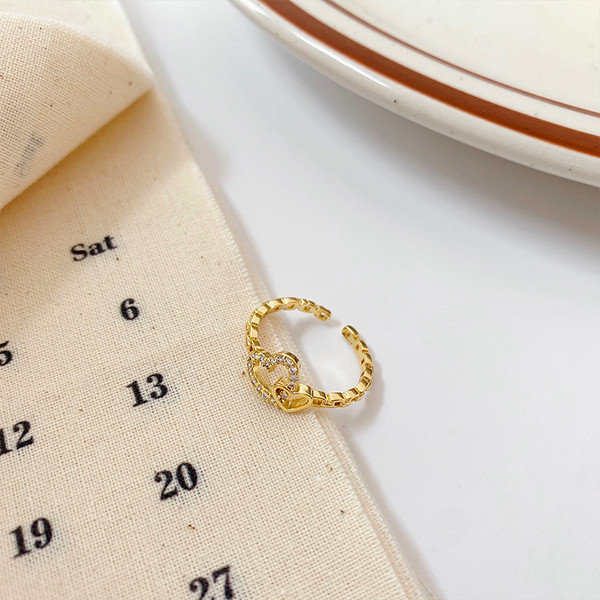 Hétköznapi vékony női gyűrű szívvel és kövekkel